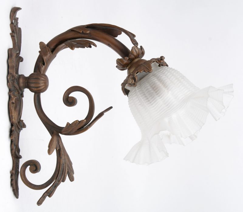 Een metalen wandlampje met glazen kap. Tijdperk art nouveau.