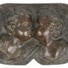 Twee bronzen reliëfs, waarbij één met engeltjes en één met een hond. De tweede gesigneerd.
