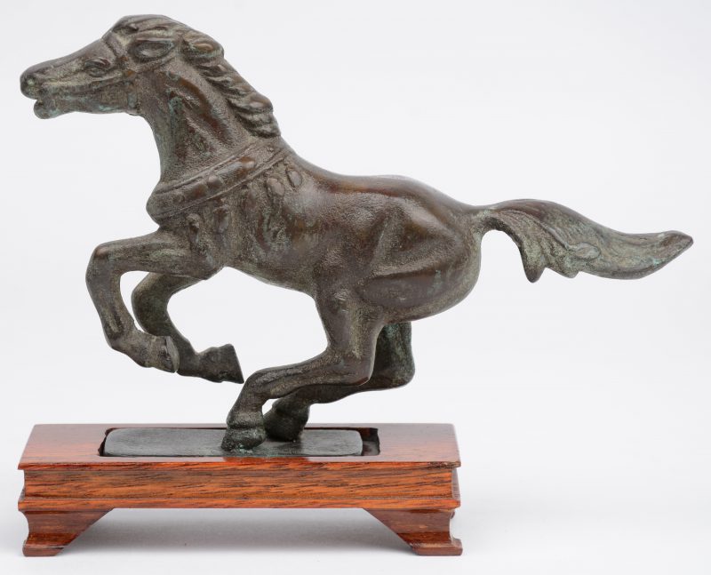 Een Chinees bronzen paardje op houten sokkeltje.