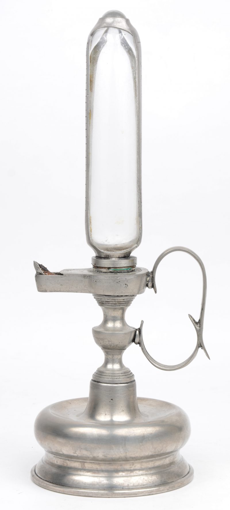 Een oude tinnen olielamp met maatglas.