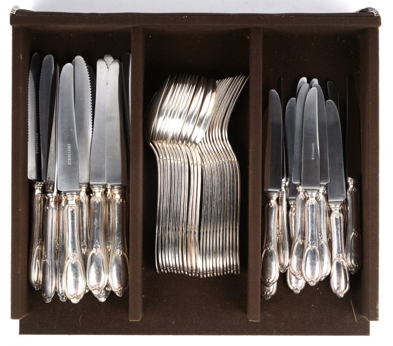Een compleet bestek voor twaalf personen, bestaande uit lepels, vorken, grote en kleine messen.