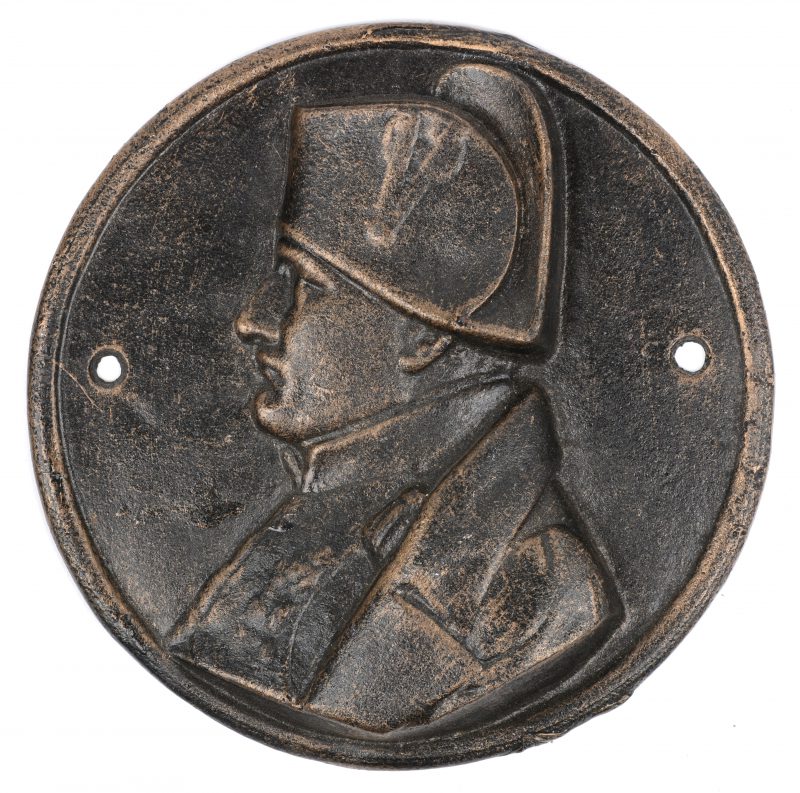 Een metalen plaquette met Napoleon in profiel.
