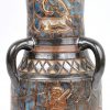 Een vaas van steengoed met drie oren en een meerkleurig geglazuurd decor met primitieve voorstellingen. Onderaan gemerkt.