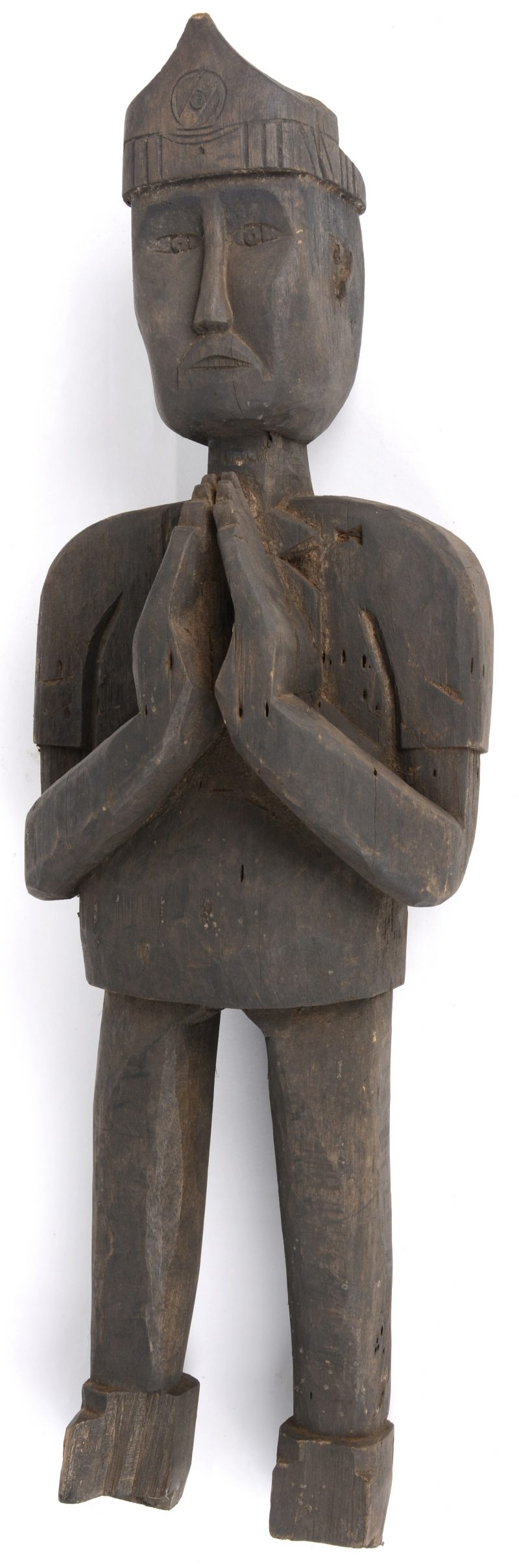 Een gebeeldhouwd houten beeld van een biddende man. Laos.