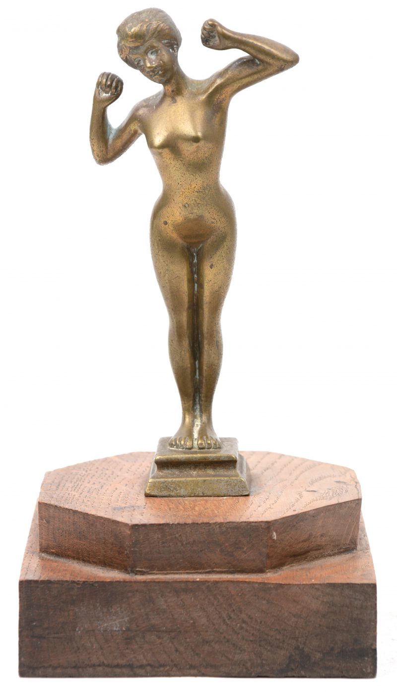 “Vrouwelijk naakt”. Een bronzen beeldje op een houten voetstuk.