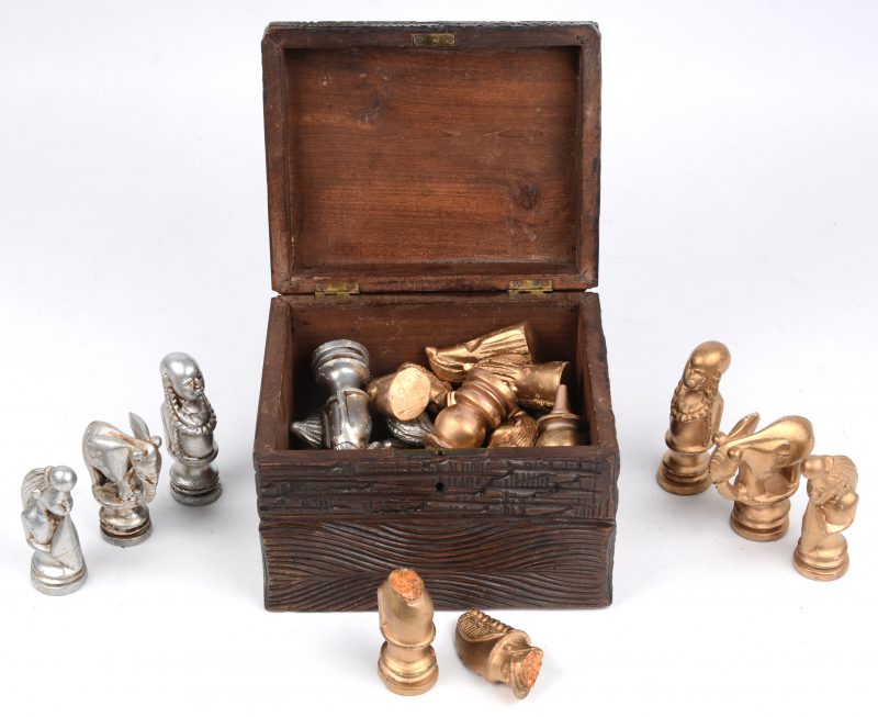 Een set gipsen schaakstukken in gebeeldhouwd houten kistje.