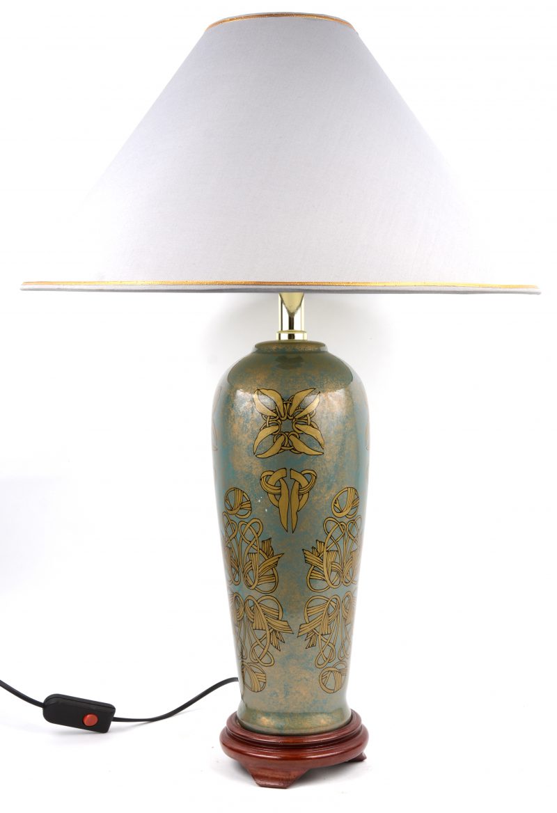 Een aardewerken lampv met met verguld decor op blauwe fond.