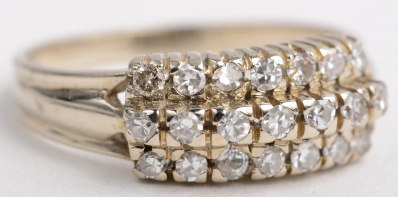 Een 14 K wit en geelgouden ring bezet met drie rijen briljanten met een gezamenlijk gewicht van +- 0,40 ct.