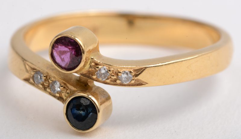 Een 18 K geelgouden ring bezet met vier briljantjes en een robijn en saffier met een gezamenlijk gewicht van +- 0,20 ct.