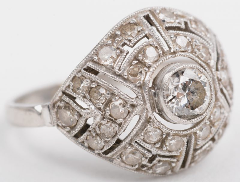 Een art deco platina ring bezet met diamanten oude slijp met een gezamenlijk gewicht van +- 50 ct. en een centrale briljant van +- 0,40 ct.