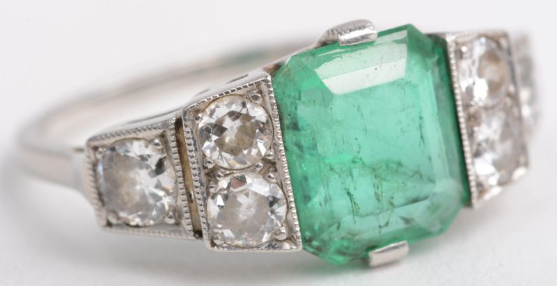 Een art deco platina ring bezet met diamanten met een gezamenlijk gewicht van +- 0,70 ct. en een centrale smaragd van +- 2 ct.