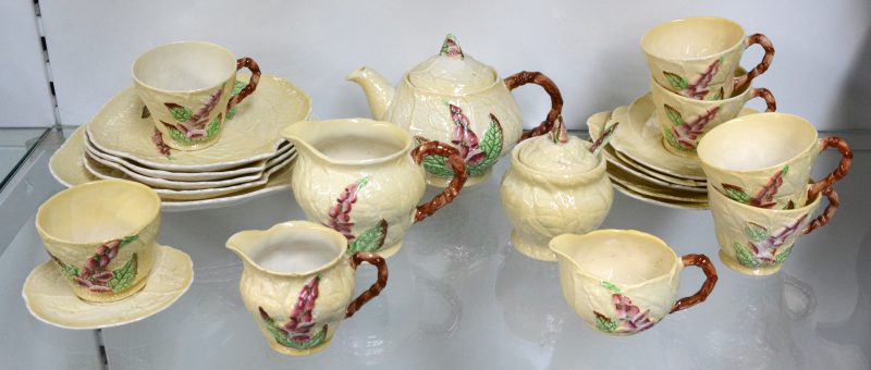 Een Engels aardewerken theeserviesje, bestaande uit vijf kopjes met schoteltjes, vier cakebordje, een gebakbordje, een theepot, een suikerpot, twee melkpotjes, waarbij één met schoteltje en een honingpot met lepeltje. Onderaan gemerkt.