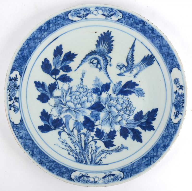 Een schotel van blauw en wit Chinees porselein met een decor naar de Compagnie des Indes. Einde XIXde eeuw.