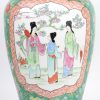 Chinese porseleinen vaas met een decor van personages op een groene fond.