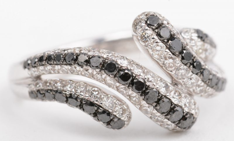 Een 18 K witgouden ring bezet met witte en zwarte diamanten met een gezamenlijk gewicht van +- 1,77 ct.