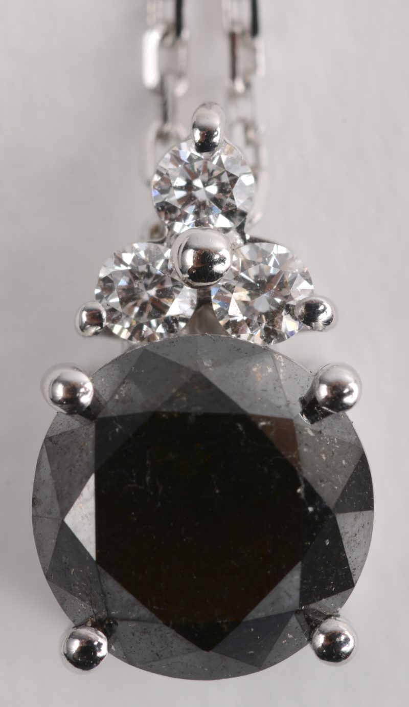 Een 18 K witgouden ketting met hanger bezet met briljanten met een gezamenlijk gewicht van +- 0,11 ct. en een zwarte diamant van +- 2,12 ct.