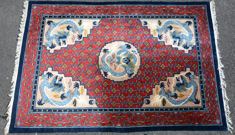 Een handgeknoopt Chinees wollen tapijt met draken in het decor.