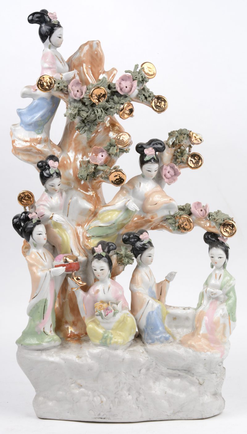 Een groep van meerkleurig en verguld porselein met zeven geisha’s bij een boom.