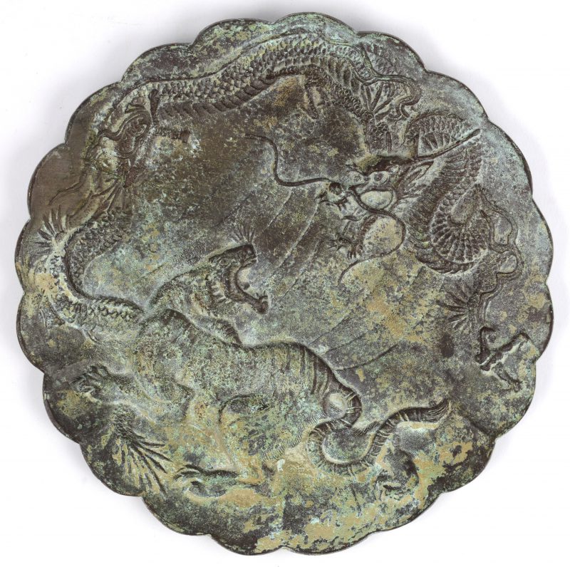Een bronzen bord met een voorstelling van een vechtende draak en een tijger.