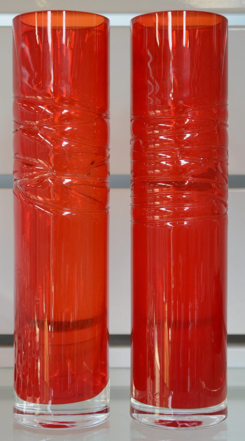 Een paar rood glazen designvaasjes.