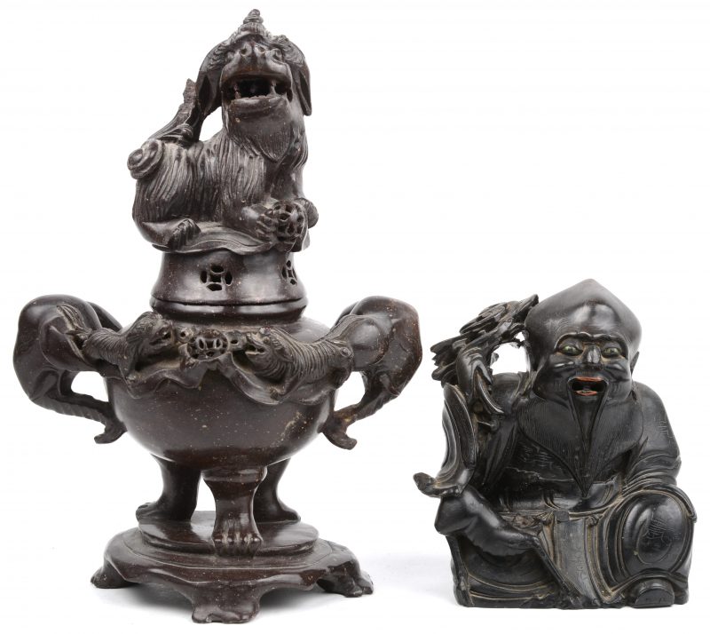 Een gesculpteerd stenen koron versierd met hondjes en olifantenkoppen en het deksel getooid met een Fo-hond en een zittende Boeddha.