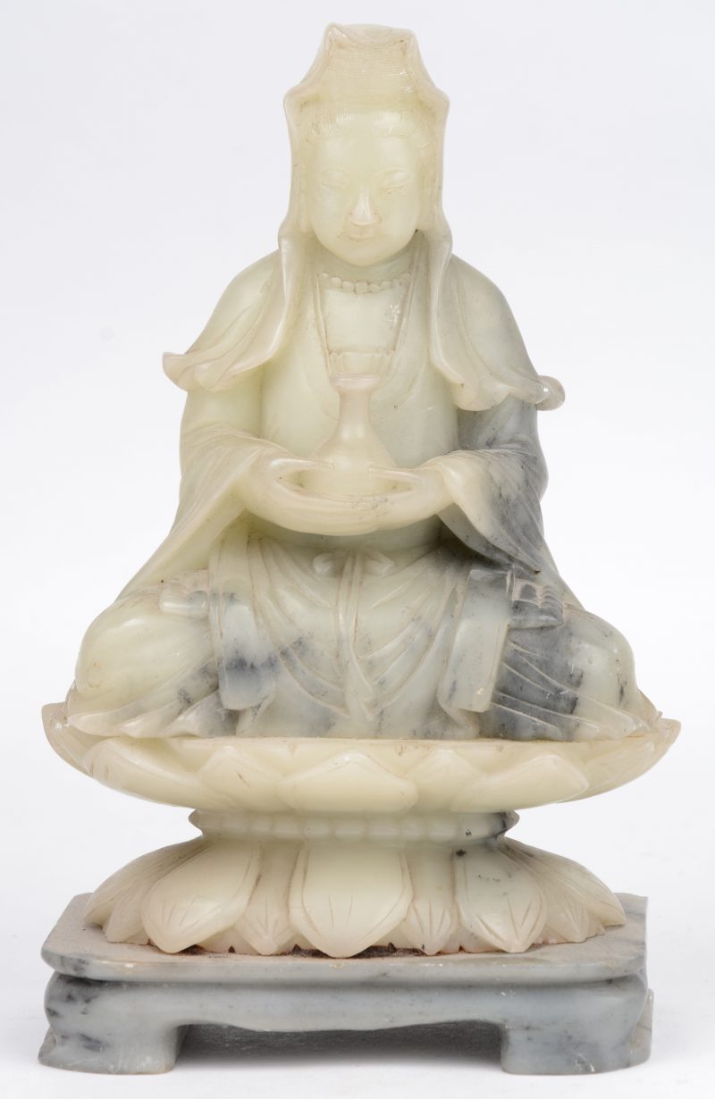 Een zittende Quan Yin van gesculpteerd jade.