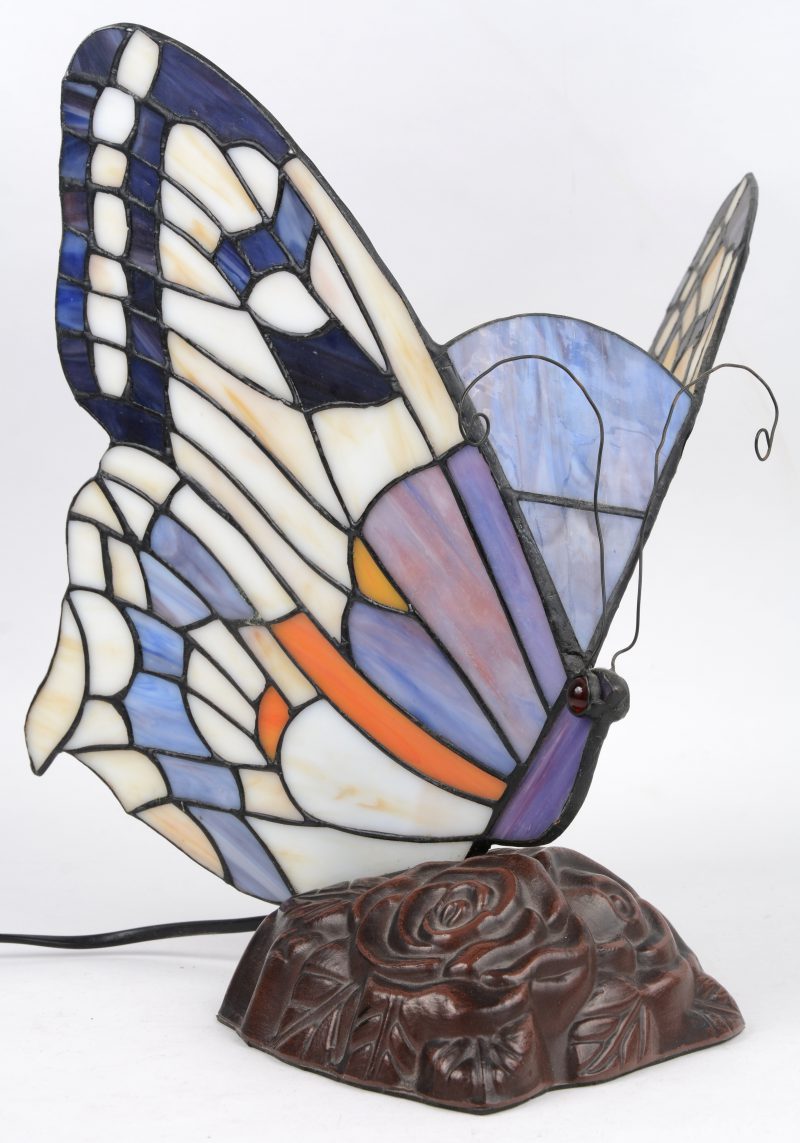 Een lampje in de vorm van een vlinder in glas in lood.