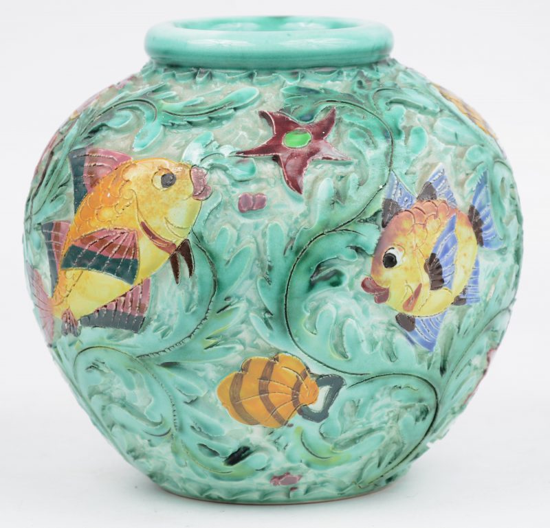 Een bol vaasje van geglazuurd aardewerk met een reliëfdecor van vissen en andere zeedieren. Onderaan gemerkt.