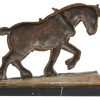 Een bronzen trekpaard op zwart marmeren sokkel. Gesigneerd.