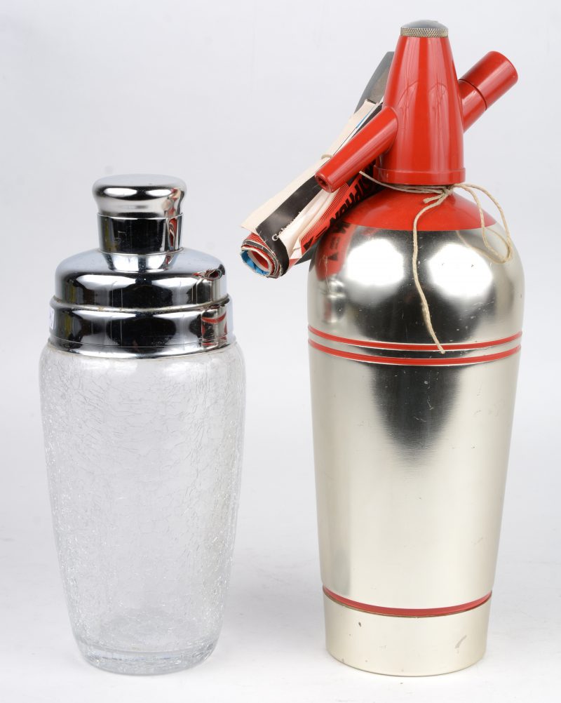 Een cosktailshaker van glas en metaal en een geborsteld metalen sodafles.