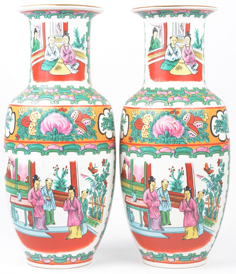 Een paar vazen van Chinees porselein met meerkleurige decors van personages. Onderaan gemerkt.
