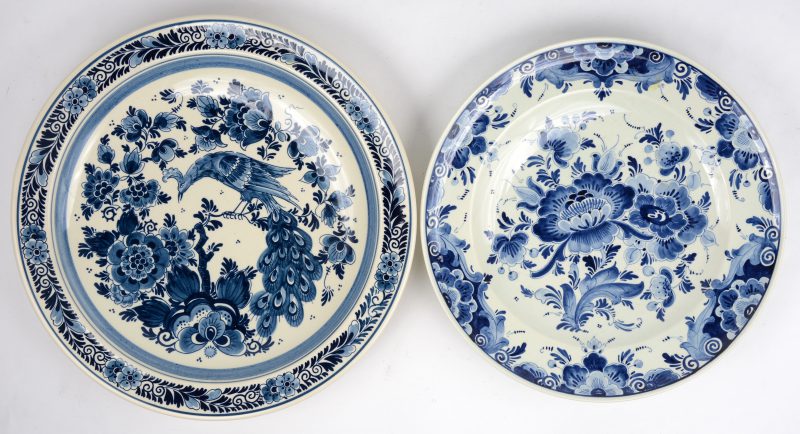 Twee schotels van blauw en wit aardewerk met Delftse decors. Onderaan gemerkt van Royal Goedewaagen en Regina.