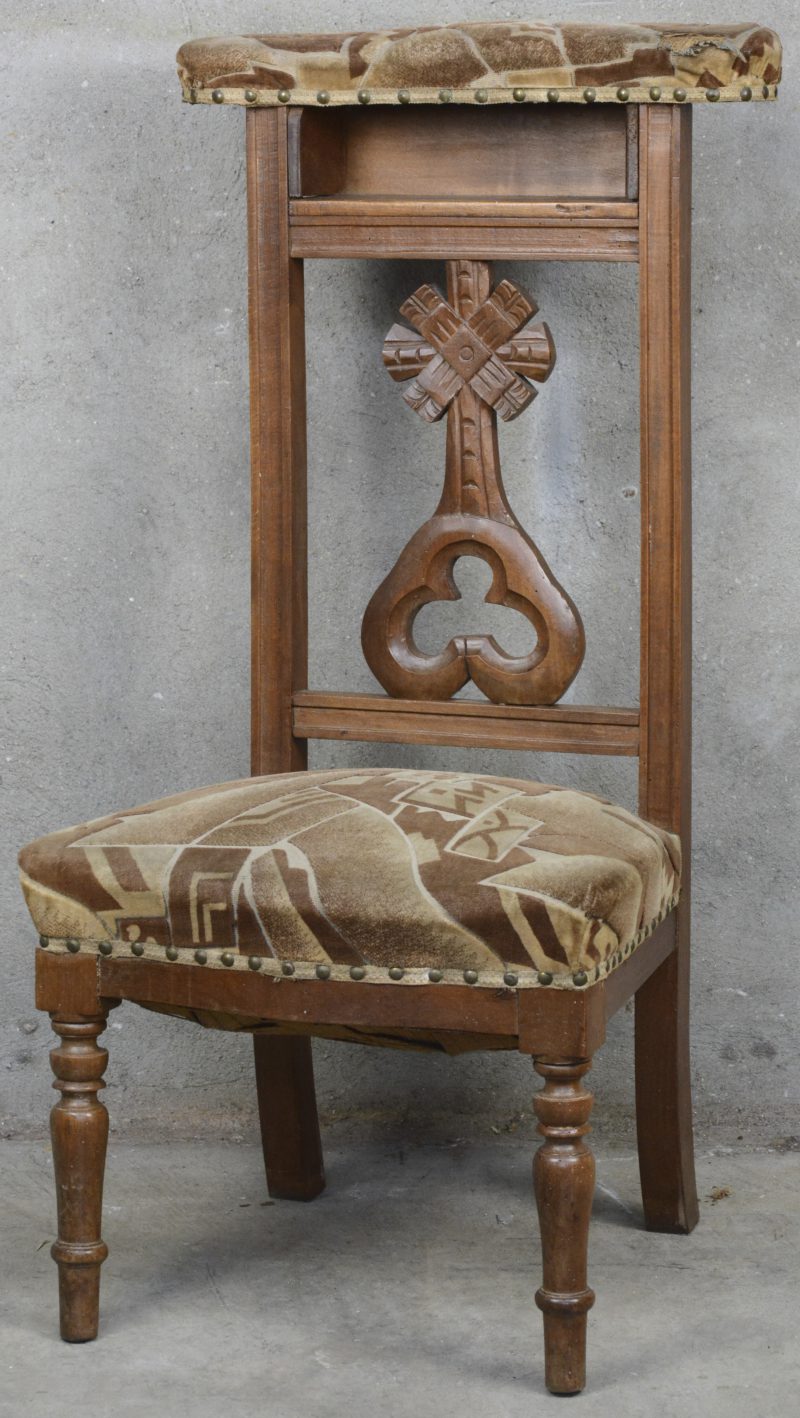 Een art deco kerkstoel met gebeeldhouwde rug.