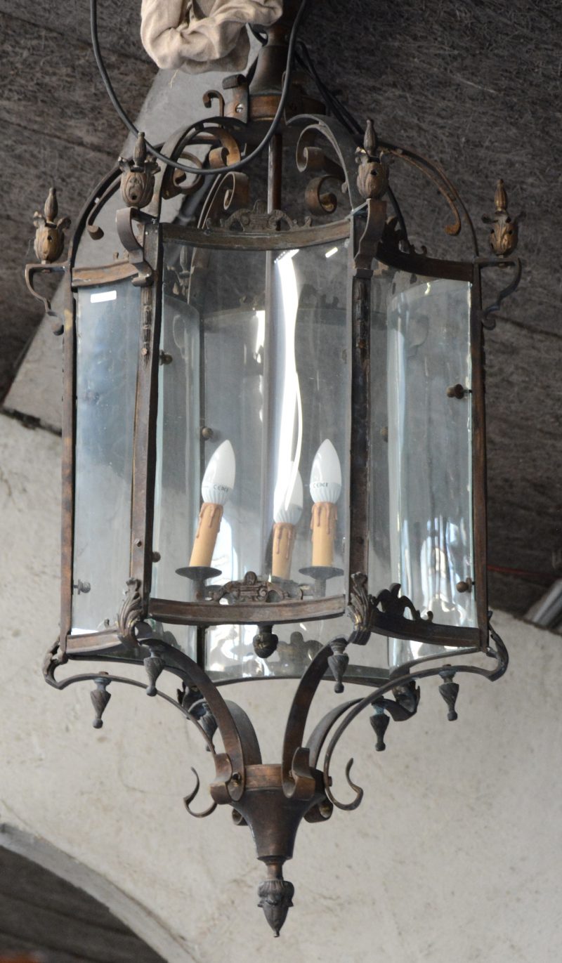 Een zeshoekige bronzen lantaarn met concave ruitjes.