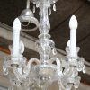 Een vijfarmif Venetiaans luchtertje, versierd met kristallen pendeloques. We voegen er twee gelijkaardige aapliques aan toe.