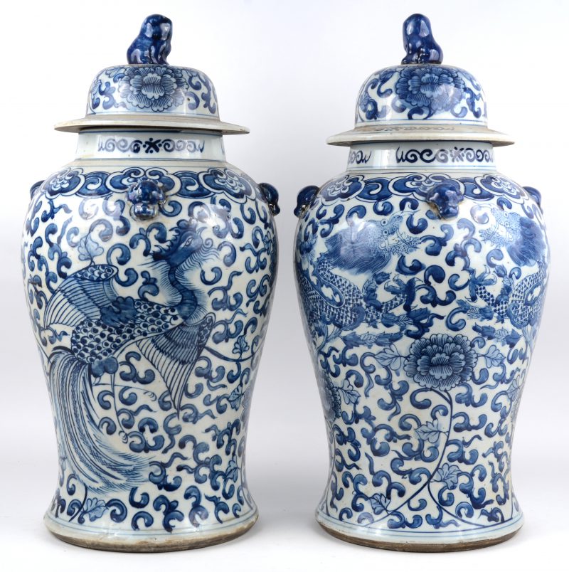 Een paar dekselvazen van Chinees porselein met blauw op wit decor van draken en feniksen.