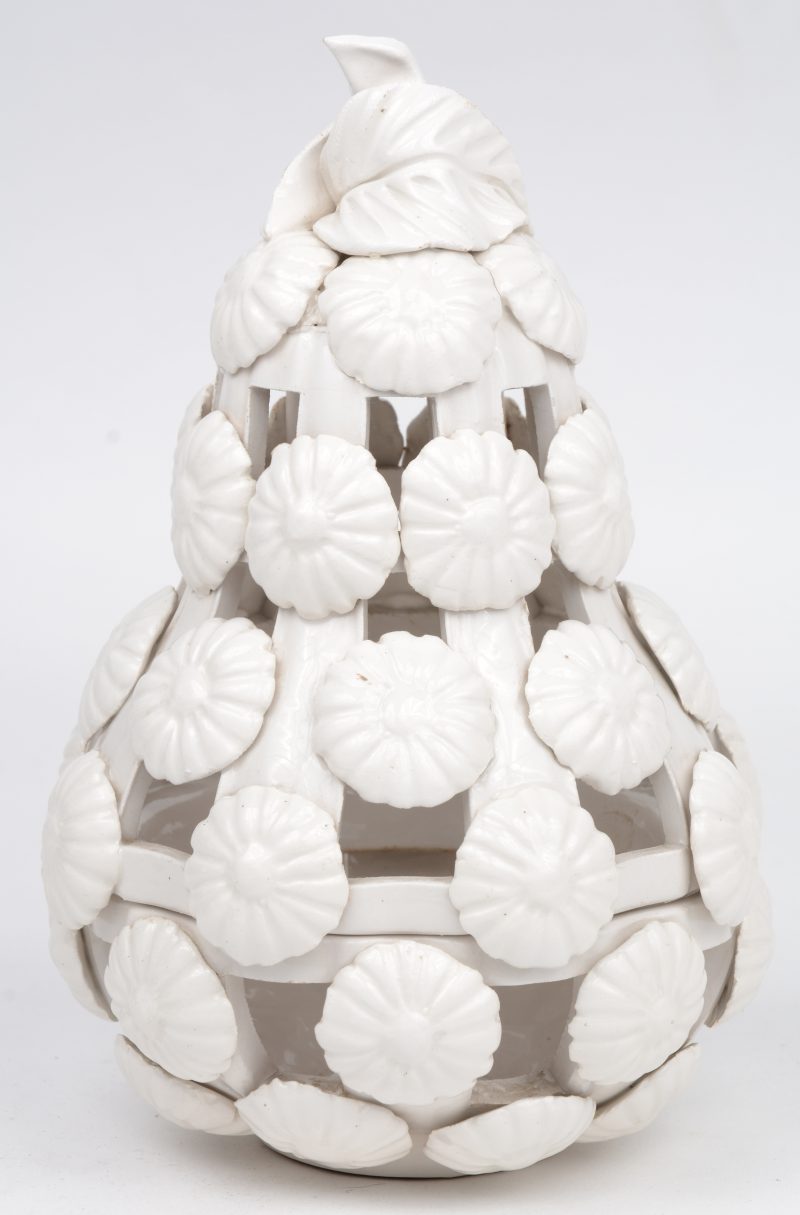 Een handgemaakte wit aardewerken kaarsenhouder met bloemen.