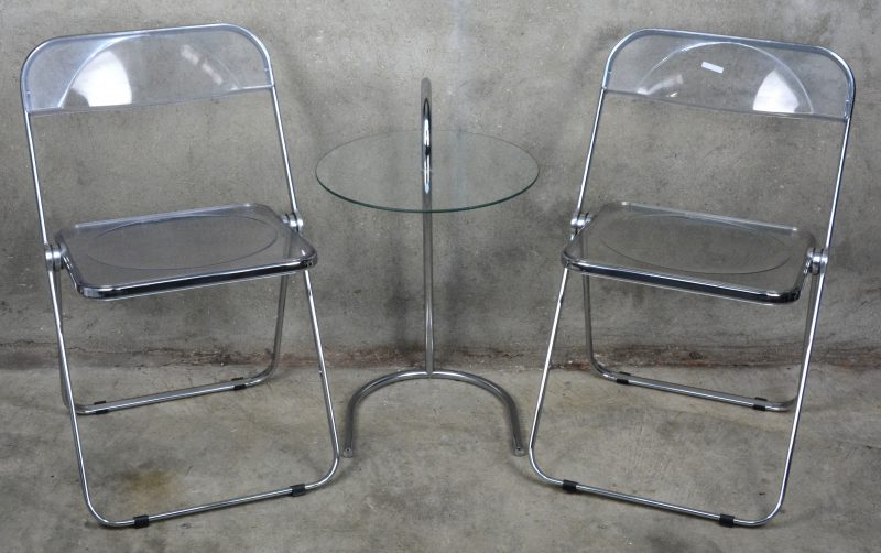 Een paar vouwstoelen (sedia plia) naar ontwerp van Giancarlo Piretti. Gemerkt. Italië, omstreeks 1970. We voegen er een bijzettafeltje met glazen blad op chromen voet aan toe.