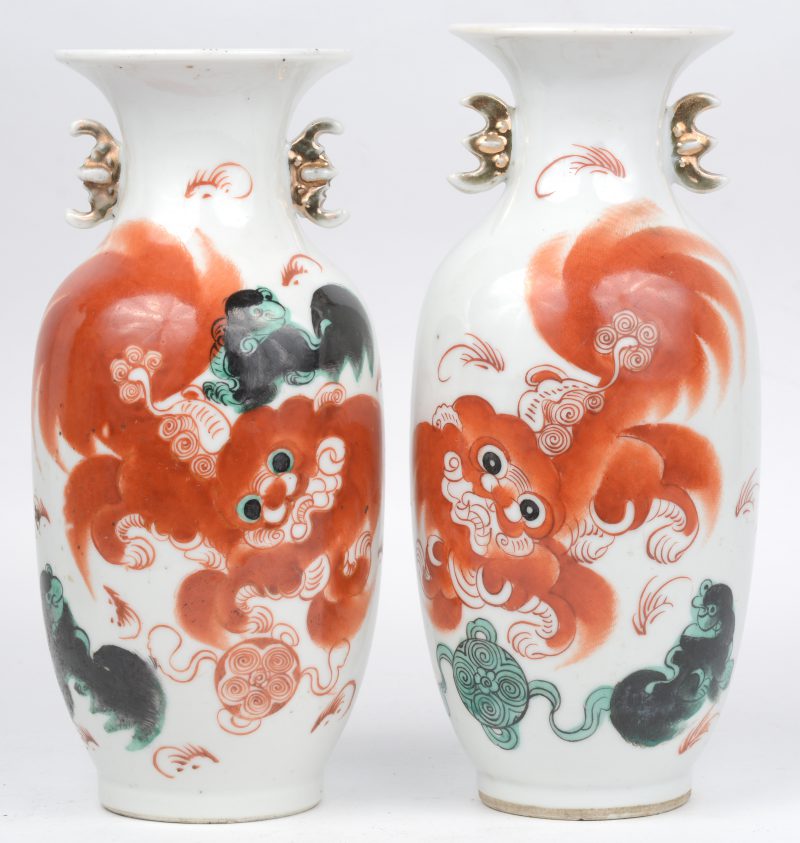 Een paar balustervaasjes van Chinees porselein met een meerkleurig decor van Fo-honden. Onderaan gemerkt.