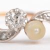 Een 18 K wit en geelgouden ring bezet met diamanten met een gezamenlijk gewicht van +- 0,20 ct. en een parel.