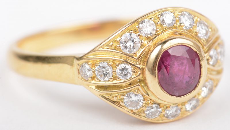 Een 18 K geelgouden ring bezet met briljanten met een gezamenlijk gewicht van +- 0,40 ct. en een centrale robijn van +- 0,50 ct.