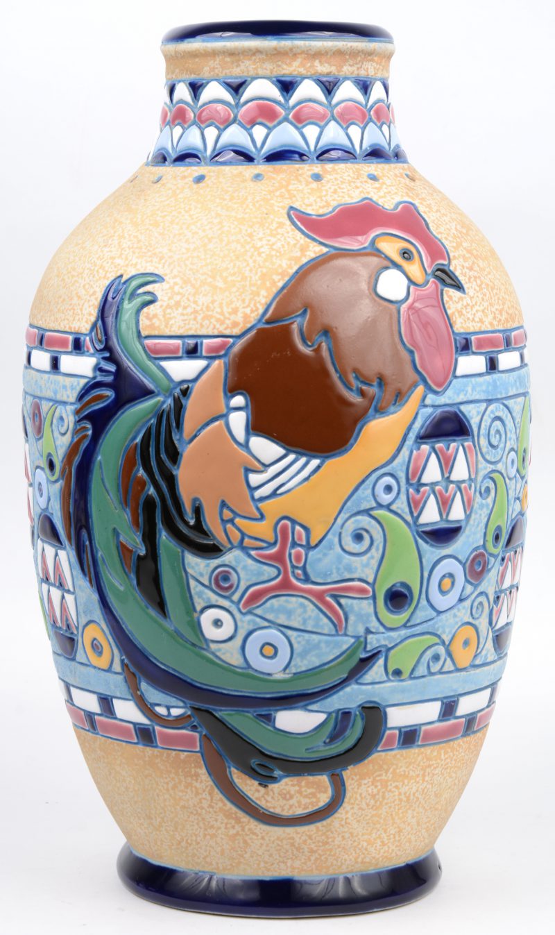 Een aardewerken vaas met een meerkleuirg geglazuurd reliëfdecor. Onderaan gemerkt.