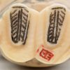 Twee Japanse netsuké’s van fijn gesculpteerd en deels gepolychromeerd ivoor. Eén stukje manco. Onderaan gesigneerd.