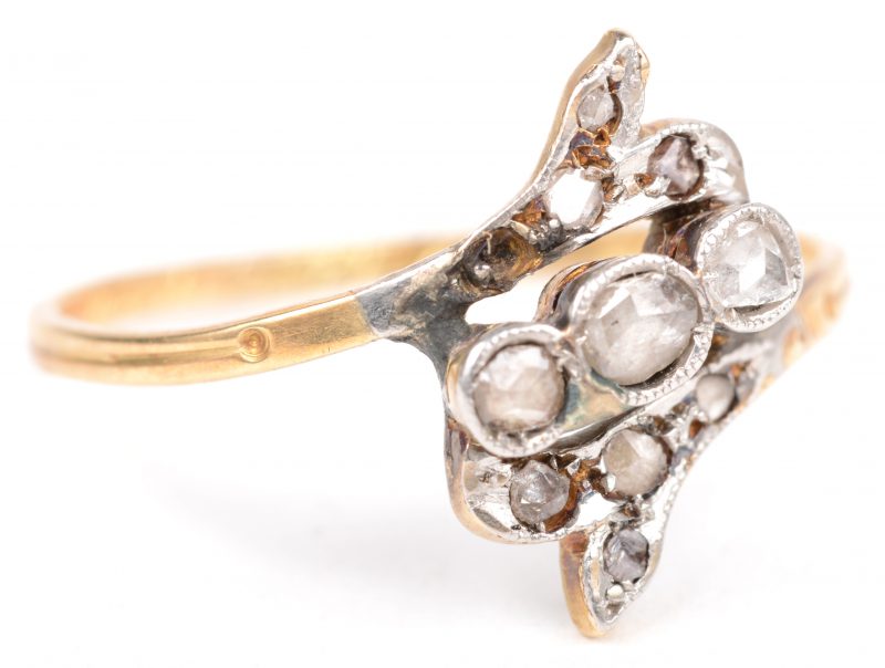 Een 18 K wit en geelgouden ring bezet met diamanten oude slijp met een gezamenlijk gewicht van +- 0,25 ct.