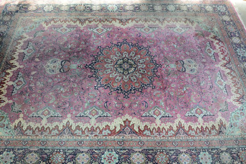 Een handgeknoopt Perzisch wollen tapijt met decor van bloemen, vogels en vlinders.