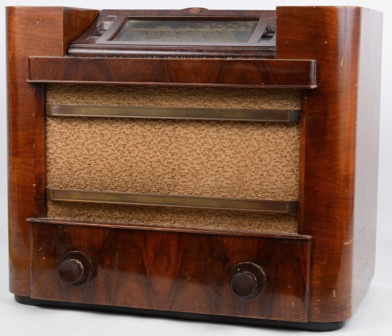 Een oude buizenradio in houten kast met bakelieten details. Type 6954 80. Jaren ‘40. Plastic zenderlijst gebarsten.
