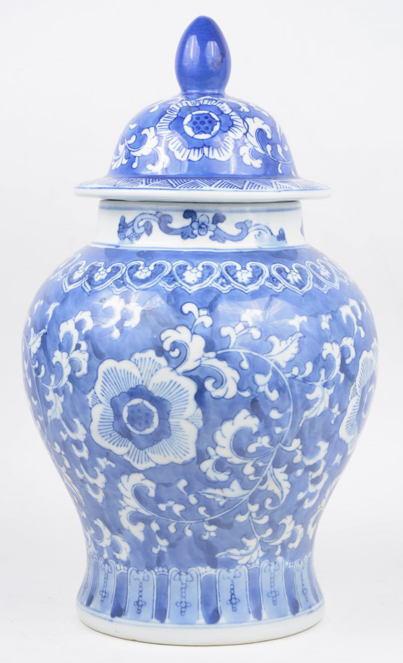 Een dekselvaas van Chinees porselein met een blaiw en wit floraal decor. Onderaan gemerkt.