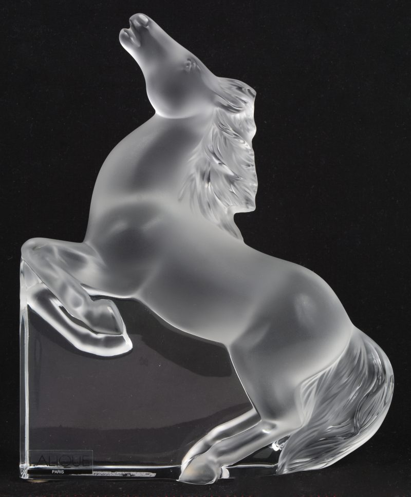 Een gegivreerd glazen beeldje van een springend paard. Onderaan gesigneerd en met label.