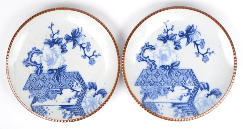 Een paar borden van Chinees porselein met een blauw op wit decor en de rand versierd met capucineglazuur.