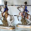 Vier meerkleurig porseleinen beeldjes van Napoleontische commandanten, bestaande uit Nansouty, Soult, Bessières en een cavalerist van de Keizerlijke garde. Achteraan gemerkt.